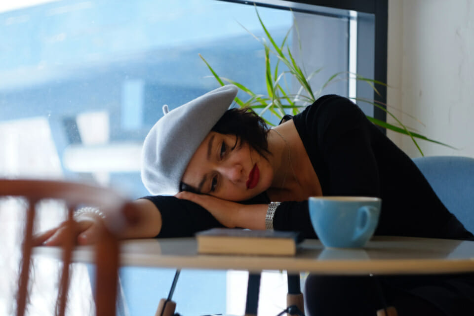 Woman with head on desk looking sad