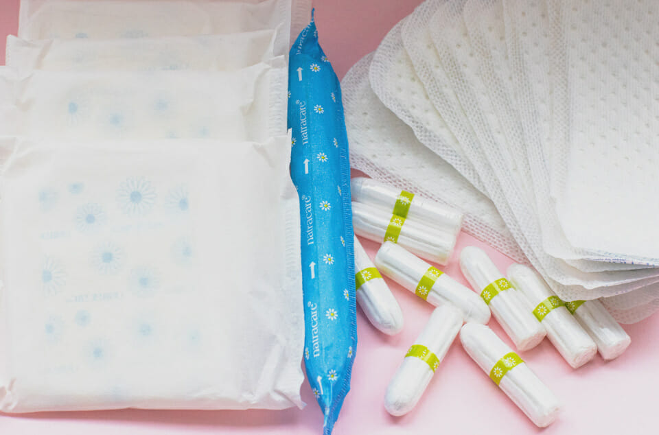 Pads, tampons and panty liners on pink background - PMS