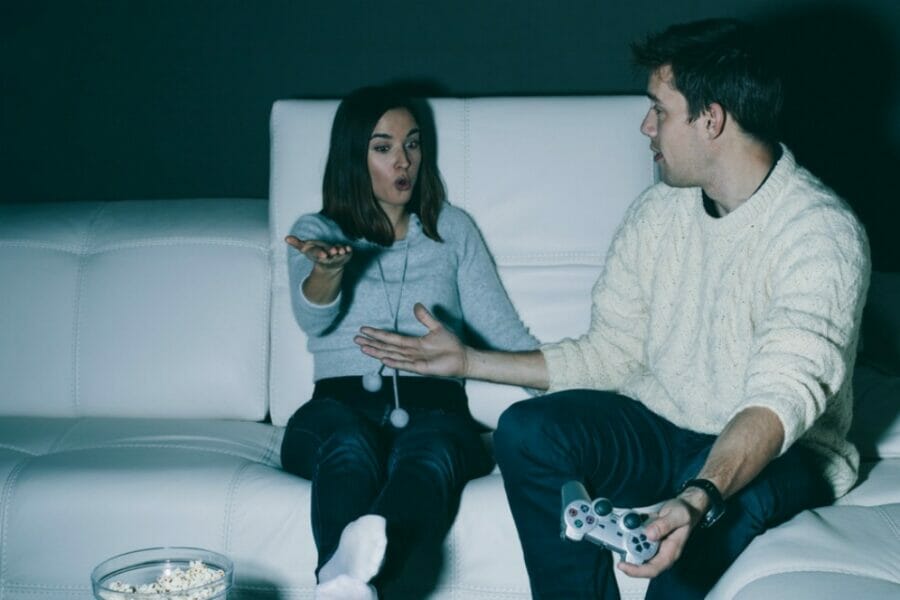 Couple fighting in a darkened room on the couch indicating some relationship stress