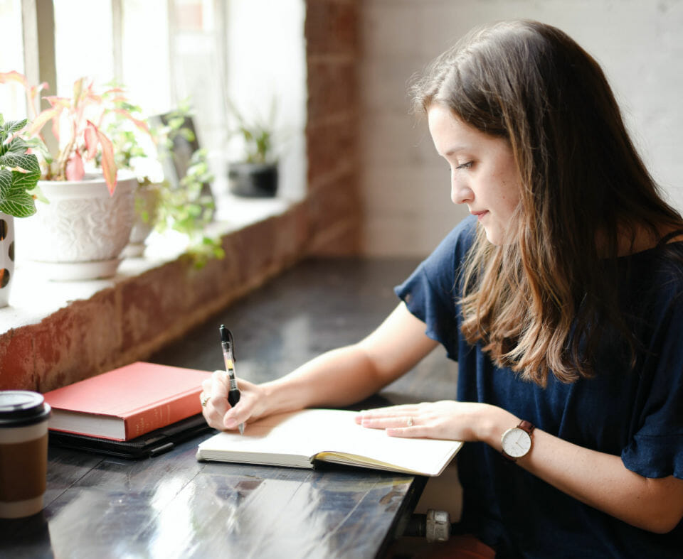 Woman writes in a journal to help her build her self-esteem