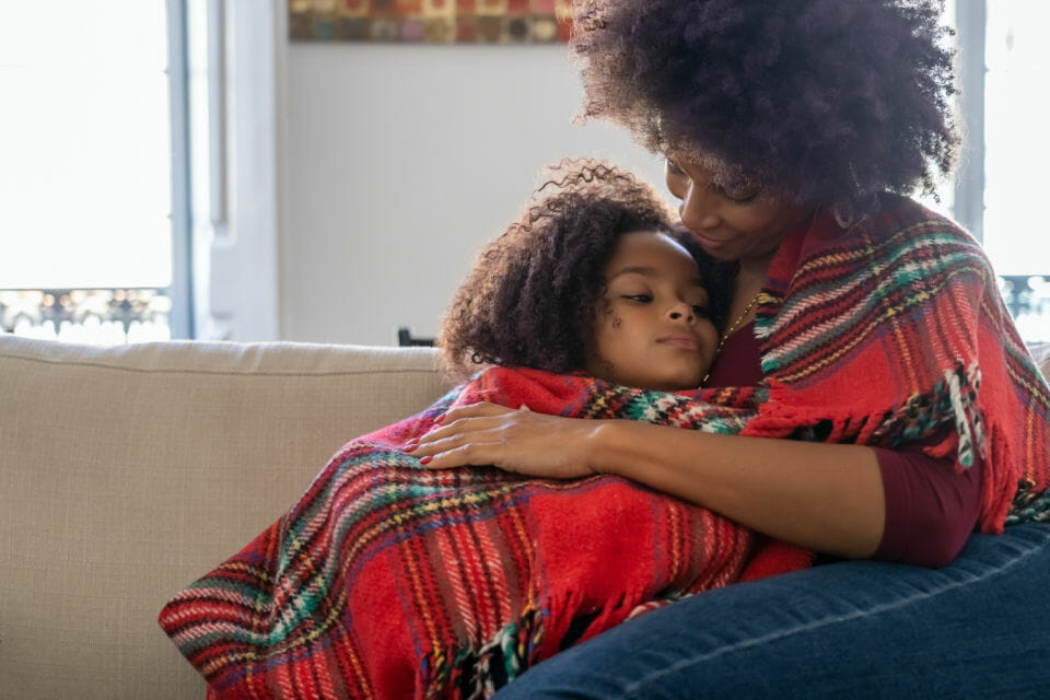 Image of a black mother and child hugging showcasing the benefits of hugging your child