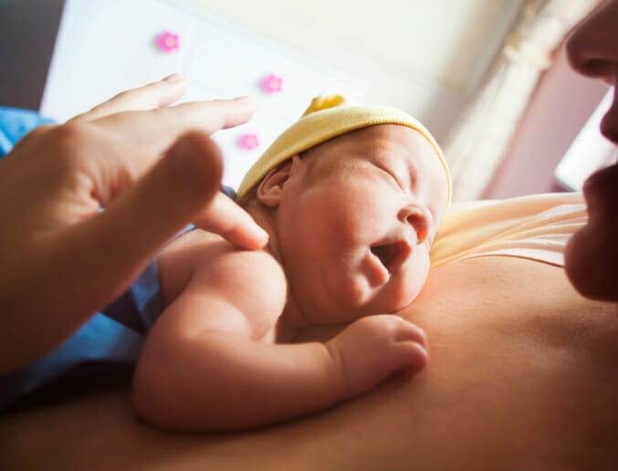 Image of a white mother and her infant child having skin-to-skin contact showing that the benefits of hugging you child from a young age